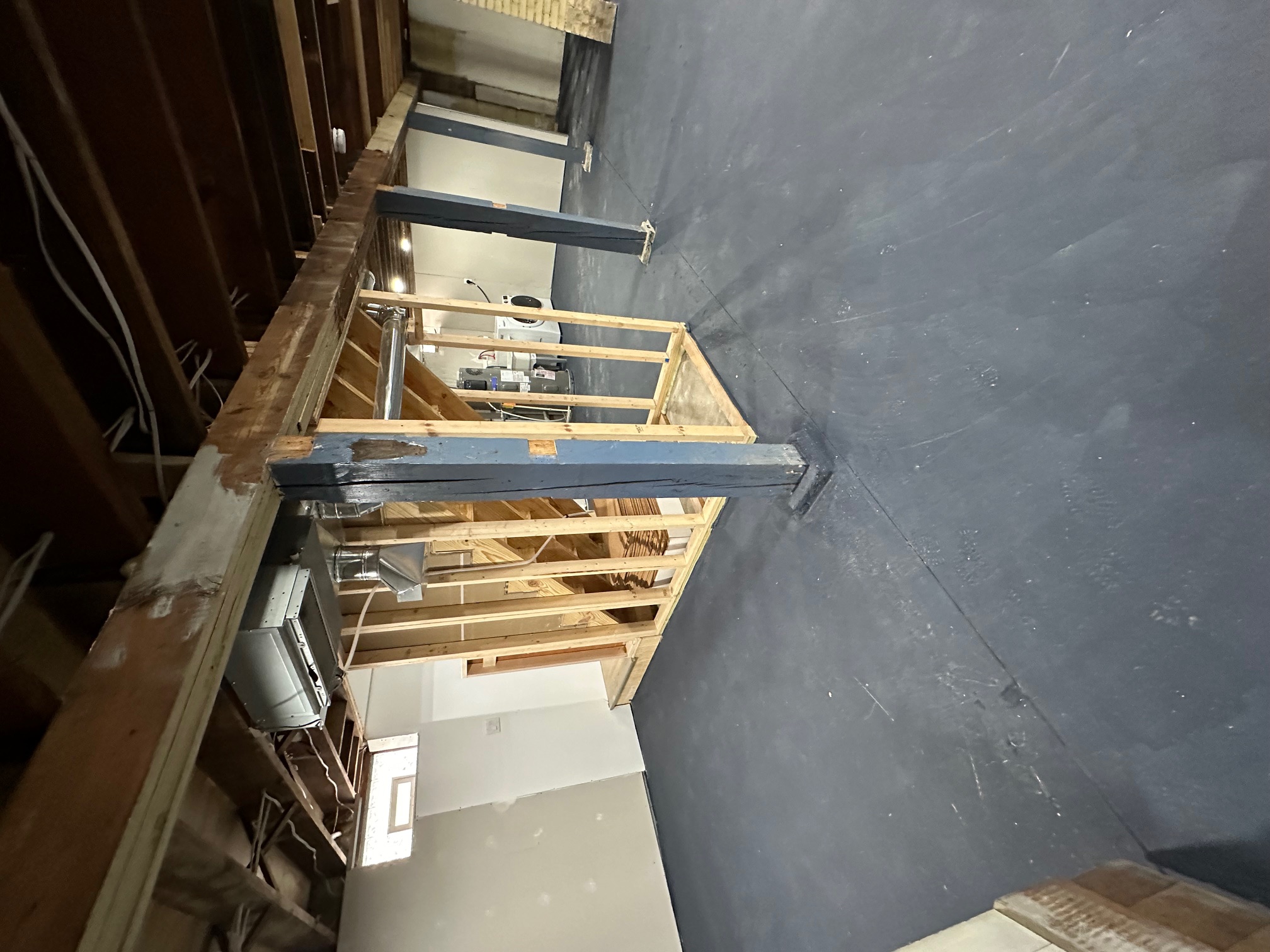 Basement framing with painted walls and exposed ceiling joists