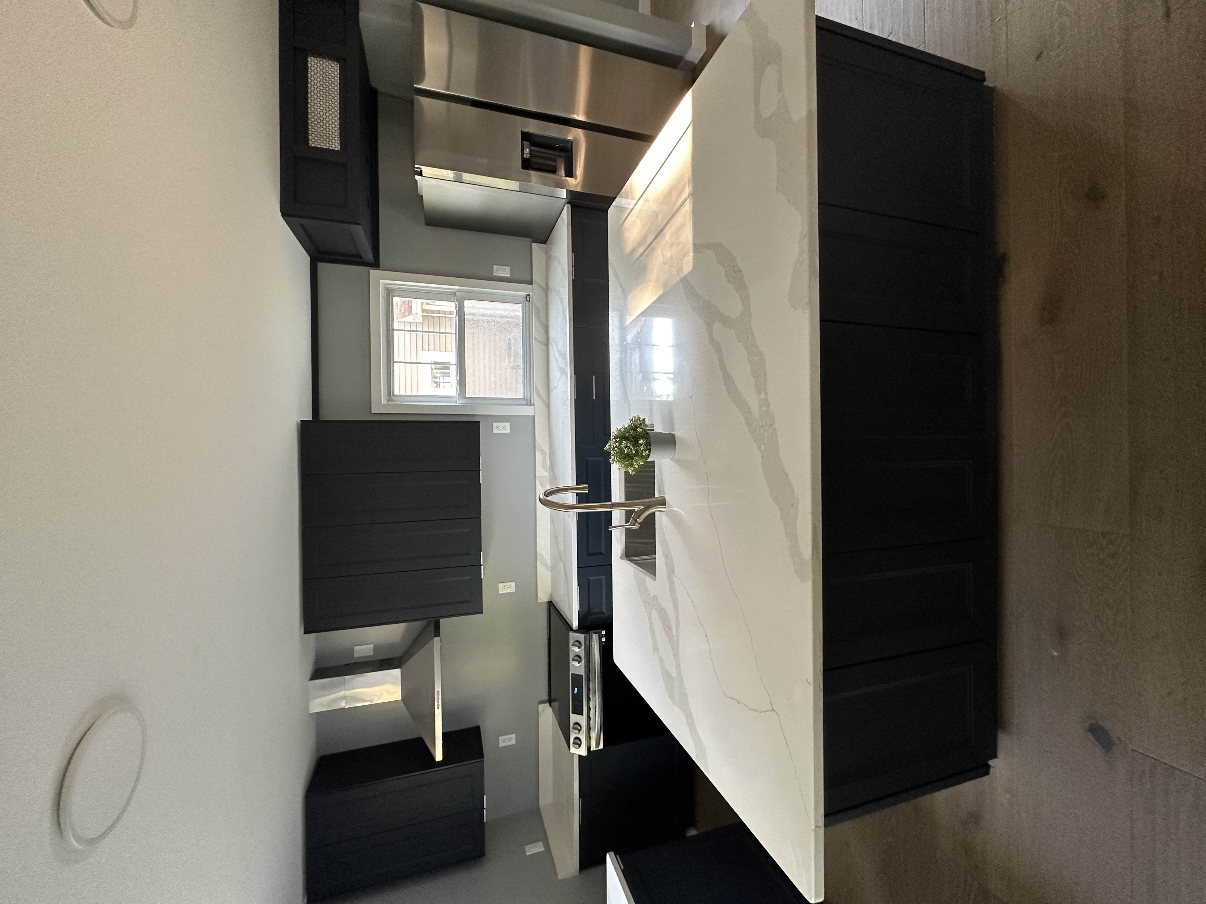 Kitchen detail — quartz island, navy cabinets and range